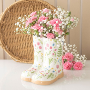 Floral print wellie boot planter filled with pink carnations and white baby's breath on a table
